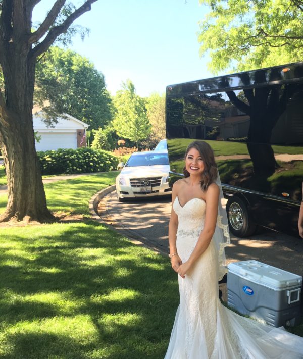 Bride standing in front of a Limos Alive party bus